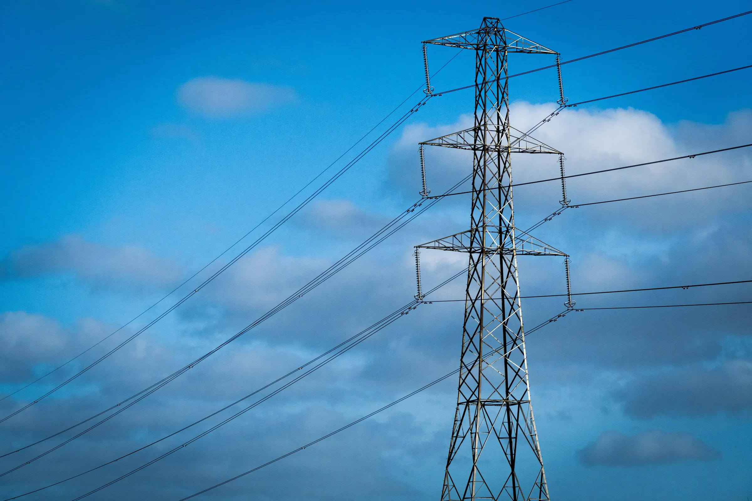 High-voltage transmission tower against a blue sky